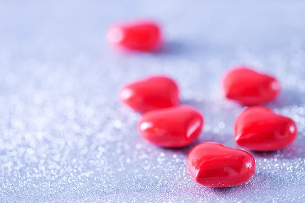 Corazones rojos sobre papel plateado — Foto de Stock