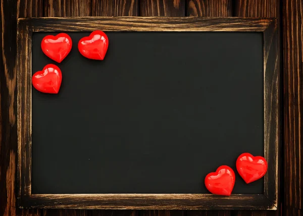 Red hearts and empty blackboard — Stock Photo, Image