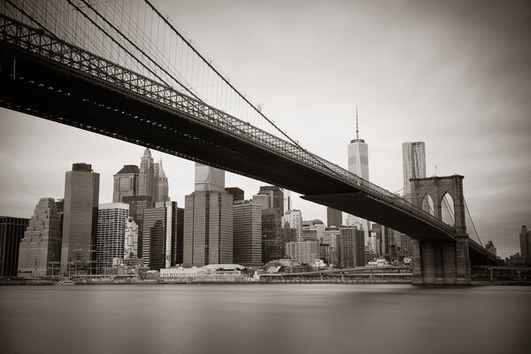 Manhattan financial district with skyscrapers and Brooklyn Bridge black and white.