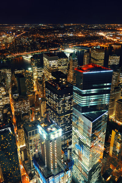 Rooftop night view of New York City downtown with urban skyscrapers