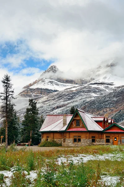 Cabin with snow capped mountain — Stock Photo, Image