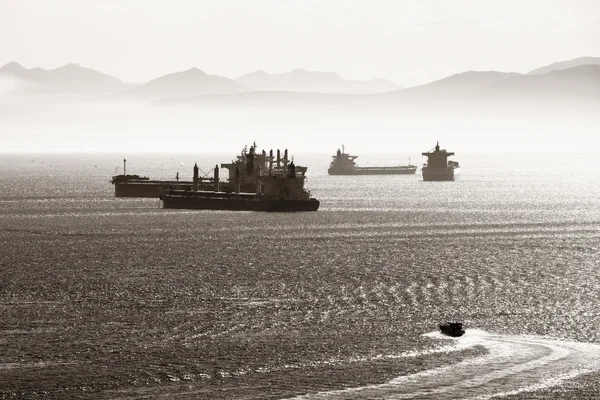 Lastfartyg med mountain silhuett — Stockfoto
