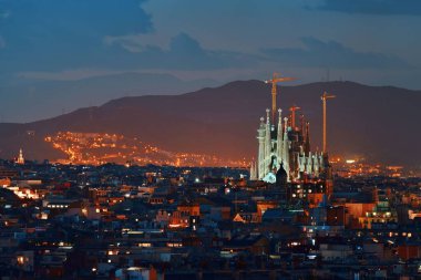 Sagrada Familia ile Barcelona, İspanya 'da gece gökdelenleri.