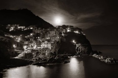 Manarola Akdeniz 'i ve Ay' ın yükselişini Cinque Terre 'deki uçurumdan gece vakti geçen binalarla gözden geçirir..