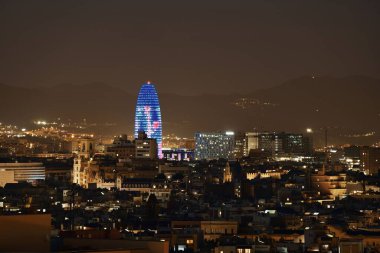 Barselona 'nın gece gökyüzü manzarası Torre Glories ve İspanya' daki şehir binalarıyla.