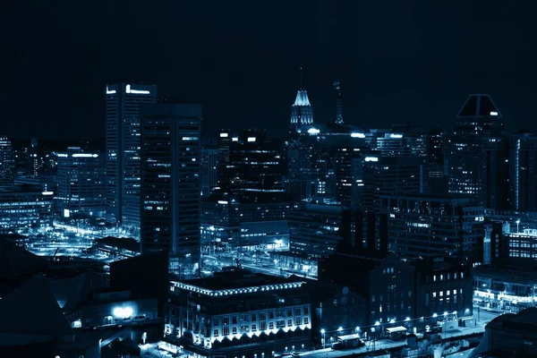 Baltimore inner harbor district rooftop view at night with urban buildings.