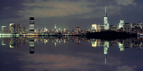 New York City at night panorama with urban architectures and reflections