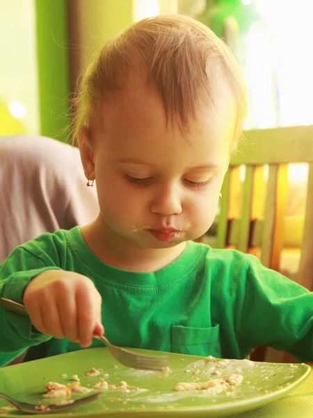 Pequena menina come panquecas com queijo (comida infantil, bio — Fotografia de Stock