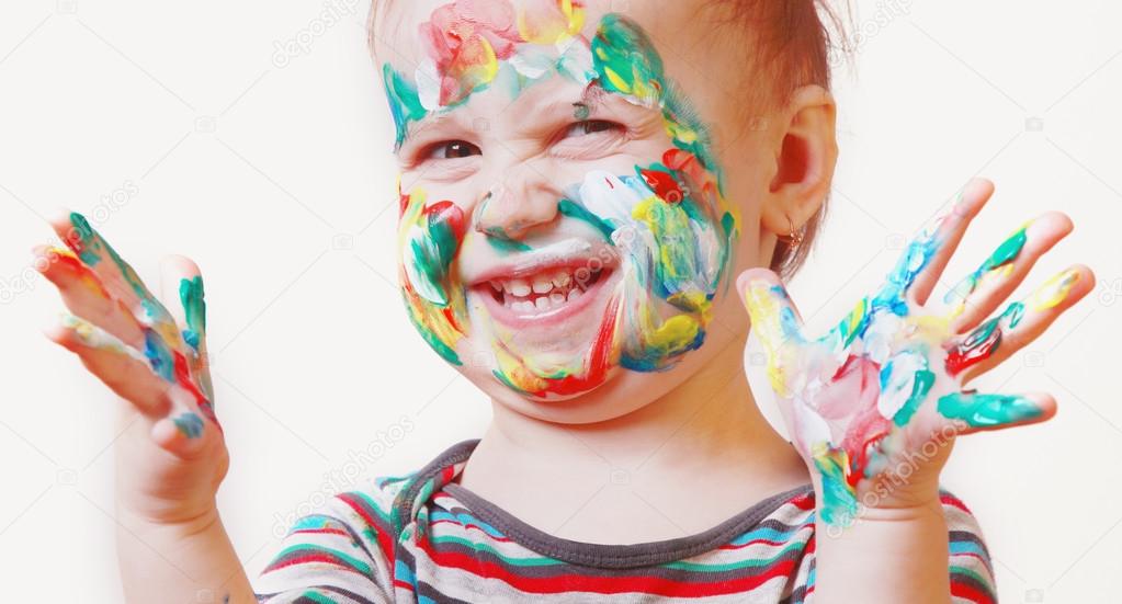 Funny happy cute little girl with colorful painted hands