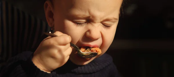 Menina aprendendo a comer com uma colher — Fotografia de Stock