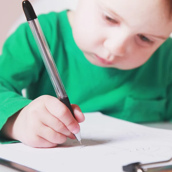 Маленькая красивая девочка пишет в своей книге — стоковое фото
