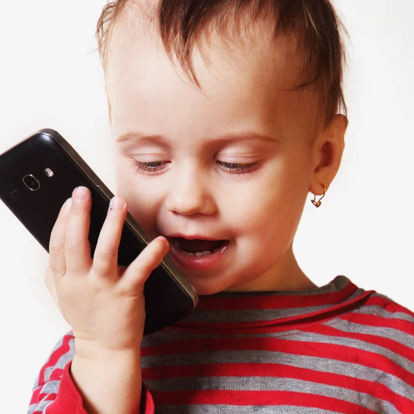 Красивая маленькая девочка говорит на смартфоне — стоковое фото