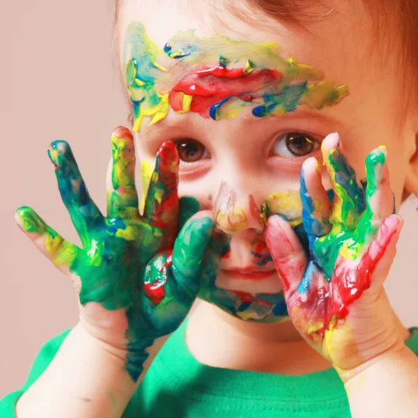 Feliz linda niña con la cara pintada de colores y las manos — Foto de Stock