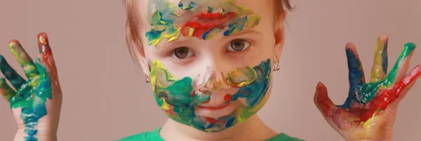 Feliz linda niña con las manos pintadas de colores — Foto de Stock