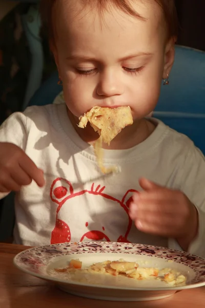 Pequena menina come panquecas com queijo (comida infantil, bio ) — Fotografia de Stock