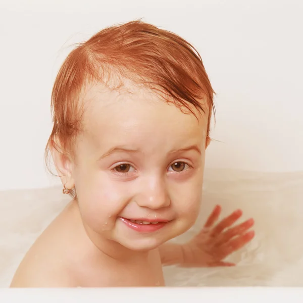Happy beautiful baby girl playing with water in the bath — Stock Photo, Image
