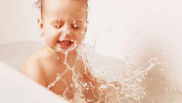 Krásná holčička, hrát si s vodou v lázni — Stock fotografie