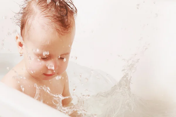 Beautiful baby girl playing with water in the bath — Stock Photo, Image
