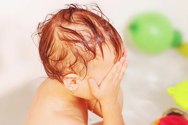 Beautiful baby girl washing face in bath — Stock Photo, Image