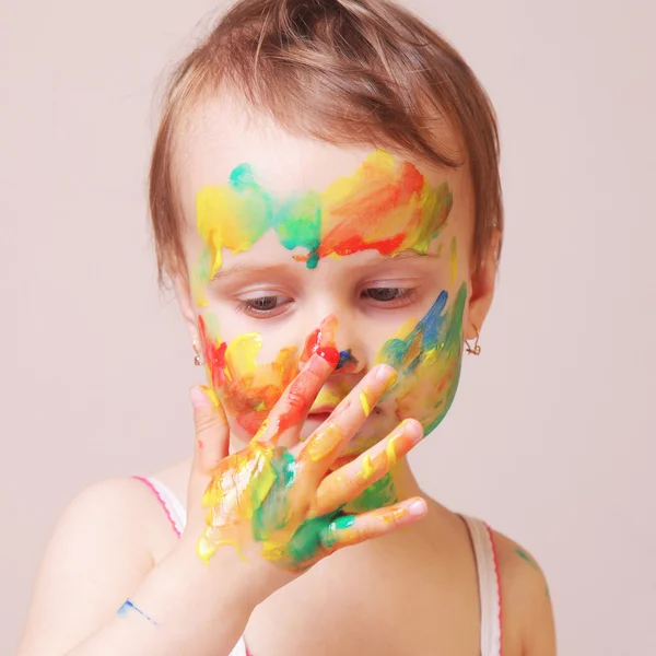 Happy cute little girl with colorful painted hands