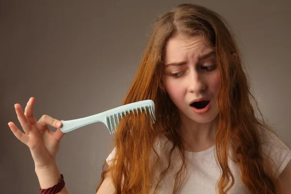 Joven mujer nerviosa cepillarse el pelo — Foto de Stock