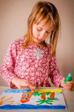 Yaz tatili hakkında rüyalar görüyor. Deniz plajını, palmiyeleri ve güneşi boyayan sevimli genç bir kızın portresi..