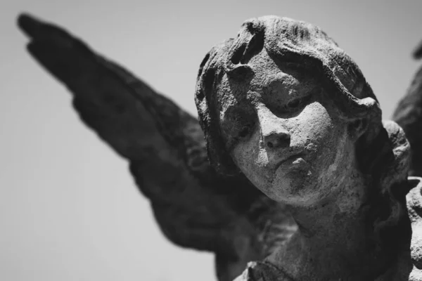 Death. Close up angel of end of life. Ancient stone statue.  Black and white image.