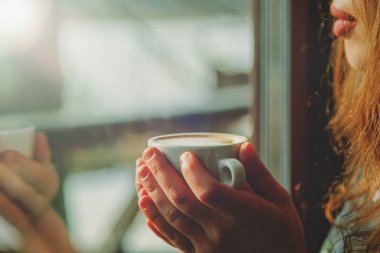 Winter holidays, christmas, hot drinks and people concept. Beautiful woman warming with cup of coffee. Selective focus.