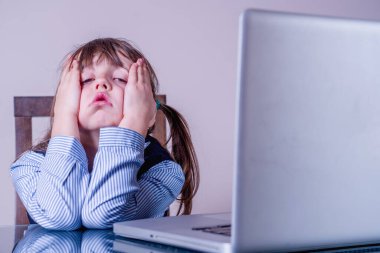 Koronavirüs salgını sırasında internetten öğrenmenin dezavantajları. Uzaktan öğrenmekten yorgun düşmüş genç bir kız. Yatay resim