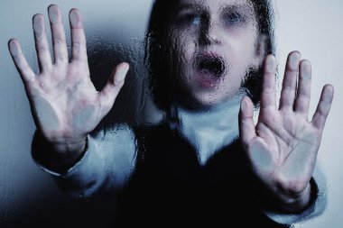 Yaklaş genç kız çocukların korku ve endişelerinin, psikolojik şiddetin ve acının sembolü olarak ağlıyor ve çığlık atıyor. Seçici odak.