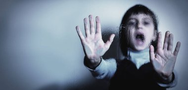 Ağlayan, çığlık atan ve çocukların korku ve endişelerinin, psikolojik şiddetin ve acının sembolü olarak dur işareti yapan genç bir kız. Seçici odaklanma. Metin veya tasarım için boşluk kopyala.