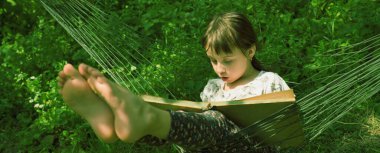 Her zaman ve her yerde öğreniyorum. Genç Beauutifuul kız dışarıda kitap okuyor parkta hamakta