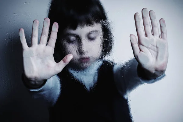 Young girl crieing, screaming and showing stop gesture as symbol of children\'s fear and anxiety, psychological violence and pain. Selective focus.