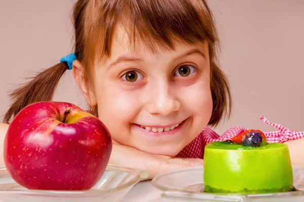 Beautiful girl having hard choice between healthy and unhealthy food.