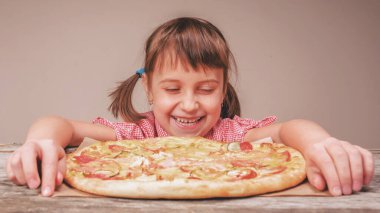 Genç ve çekici bir kız lezzetli pizzayı seviyor, bu tadı seviyor, iştahı yerinde. Aç dişi çocuğun komik yüz ifadesi.. 