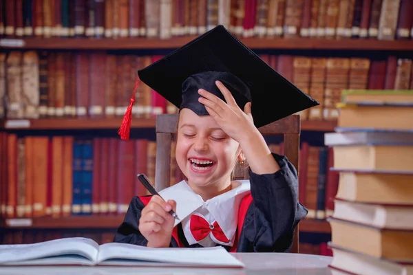 Humorous portrait of very happy master of science. Cute child girl student writing project plan of master thesis.