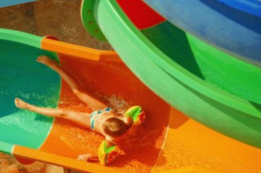 Yaz tatili konsepti. Su parkında eğlenen sevimli küçük kız çocuğu manzarası..