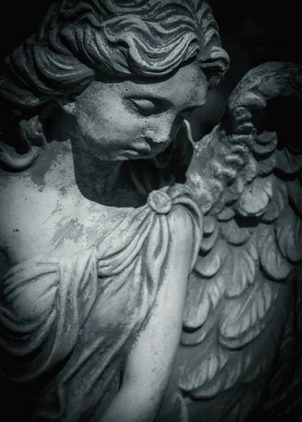 Fragment of an ancient statue of sad angel as a symbol of eternity, life and death. Religion concept.
