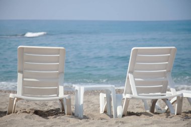 Başarısız turizm sezonu, covid-19, karantina ve salgın konsepti. Boş kumsal, sahilde kimse yok. Güzel mavi gökyüzü, sıcak hava. Gezginlerin ve turistlerin olmadığı sahil.. 