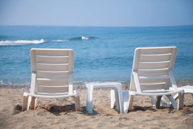 Coronavirus, covid-19, karantina ve salgın konsepti. Plaj şemsiyeli boş bir sahil, sahilde kimse yok. Güzel mavi gökyüzü, sıcak hava. Gezginlerin ve turistlerin olmadığı sahil.. 