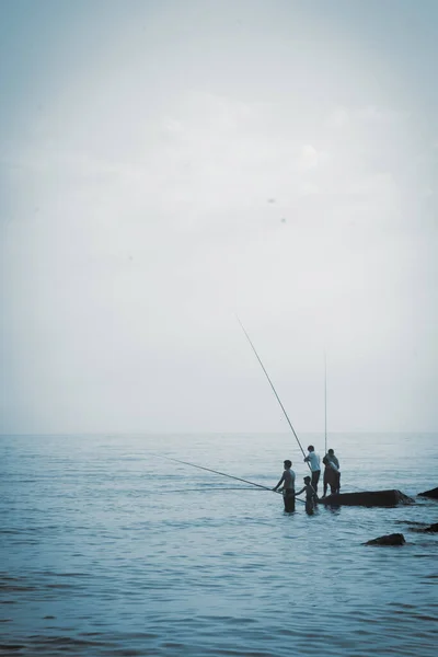 屋外の海での漁師のシルエット 夏のレジャー スポーツ 休日の概念 垂直画像 — ストック写真
