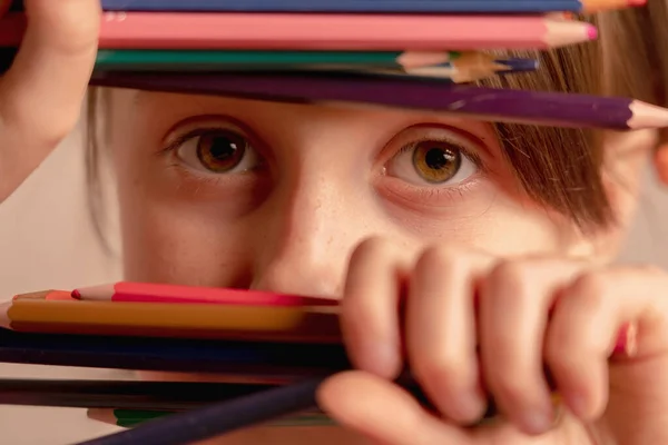 Portrait of young girl with colored pencils as a symbol of drawing lessons.