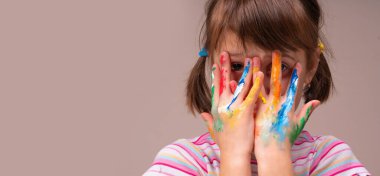 Renk, çocuklar ve kavrama konsepti. Renkli boyalı elleri olan güzel bir genç kızın portresi. Tasarım veya metin için boşluk kopyala.