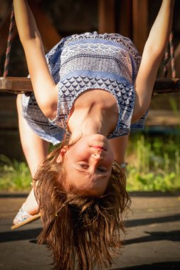 Salıncakta baş aşağı oturan güzel genç kızın portresini yakından çek. Mutluluk kavramı. Dikey resim.