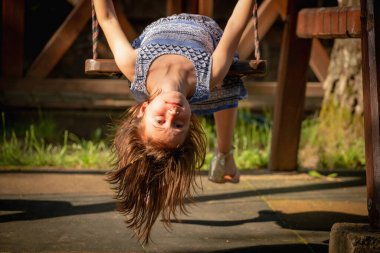 Salıncakta baş aşağı oturan güzel genç kızın portresini yakından çek. Mutluluk kavramı. Yatay resim.