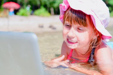 Dizüstü bilgisayarla çalışan ve sahilde buluşan genç iş kadınının komik portresi. Konsept: serbest çalışma, tatiller, mesafe çalışması, sosyal uzaklık, e-öğrenim.