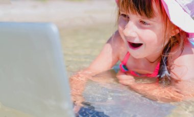 Kavramsal görüntü: Aynı anda çalış ve dinlen. Tropikal denizin sularında dizüstü bilgisayarla uzaktan öğrenilen güzel genç portresi. Yatay resim. 