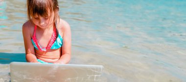 Kavramsal görüntü: Aynı anda çalış ve dinlen. Genç kız tropikal denizin güzel sahillerinde uzaktan öğreniyor. Metin veya tasarım için boşluk kopyala.