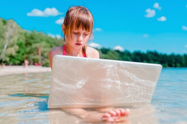 Ofis sahil konsepti üzerinde çalışıyor. İş kadını tropikal denizin güzel sahillerinde uzaktan çalışıyor. Yatay resim.