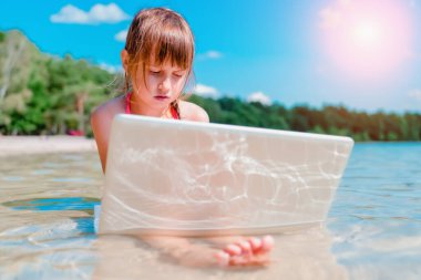 Aynı anda hem çalış hem dinlen. Tropikal denizin sularında dizüstü bilgisayarla uzaktan öğrenilen güzel genç portresi.. 